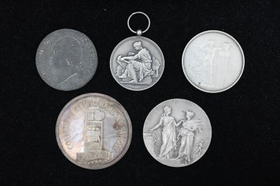 quatre pièces d'argent et une pièce d'argent posées sur une surface noire