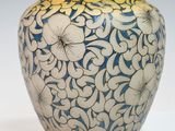un vase bleu et blanc orné de fleurs blanches