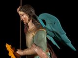 a statue of an angel holding a bird on a pole