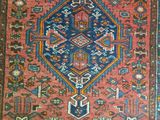 a red and blue rug with a diamond design on it