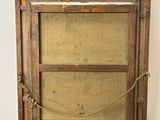an old wooden easel with a canvas on top of it next to a white wall