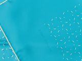 a close up of a blue quilt with white sprinkles on it