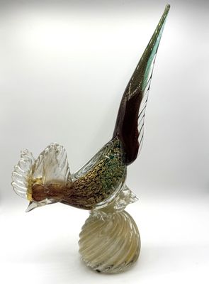 un oiseau en verre perché sur un coquillage
