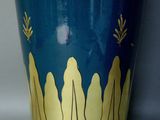 a blue vase with gold designs on it on a white surface