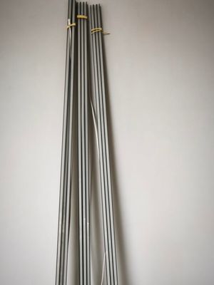 Plusieurs tuyaux métalliques sont alignés contre un mur dans une pièce
