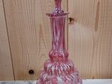 a pink glass vase sitting on a marble table