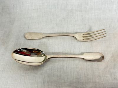 two spoons and a fork sitting on a table