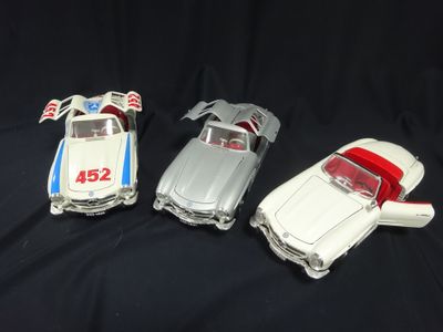 three toy cars are sitting side by side on a black surface
