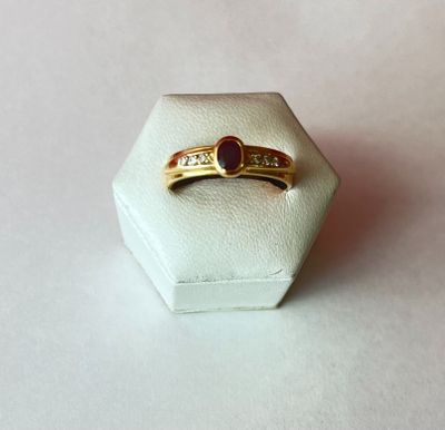 l'image d'une bague en or contenant une pierre rouge