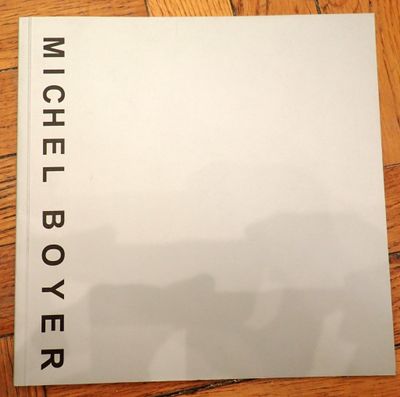 a white book sitting on top of a wooden floor next to a wooden floor