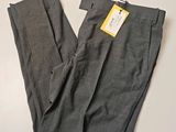 Le pantalon est gris et porte une étiquette jaune.