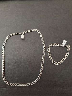 a silver necklace and bracelet on a black surface