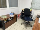 a desk with a computer and a chair in a room