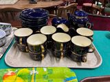 a tray with cups and plates on it on a table