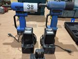 two electric drillers sitting on top of a wooden table in a workshop