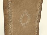 an old book is sitting on a white surface with a white background