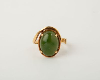 a gold ring with a green jade stone in the center