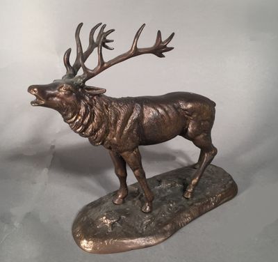 statue d'un cerf posé sur un rocher, sur lequel sont posés ses bois