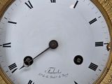 a gold clock with roman numerals on the face of it