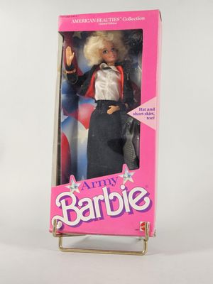 Poupée Barbie « Happy Barbie » dans sa boîte, sur fond blanc avec un arrière-plan rose