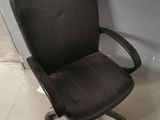 a black office chair sitting in front of a white wall
