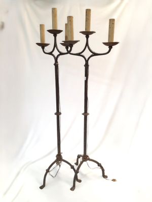 un grand chandelier en fer surmonté de cinq bougies