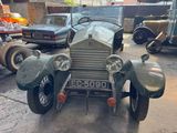 a vintage car parked in a parking lot with other cars