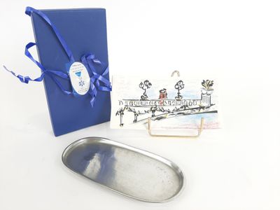 une boîte bleue ornée d'un ruban bleu et un plateau argenté orné d'un ruban bleu