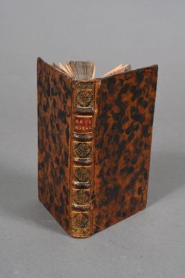 an old book with a brown cover sitting on top of a table