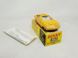 yellow toy car sitting on top of a box next to a packet of cigarettes
