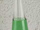 a green glass decanter sitting on a table
