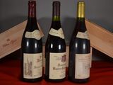 three bottles of wine sit on a table next to a wooden box