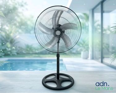 un ventilateur noir posé sur une table près d'une piscine