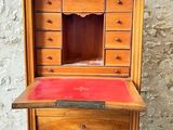 an old wooden desk with a red top and drawers