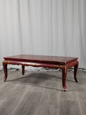 une photo d'une table basse rouge posée sur un parquet