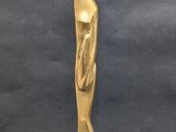 a gold statue of a woman standing on top of a wooden base