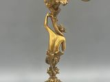 a gold colored candelab with three candles on top of it