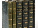 plusieurs vieux livres sont alignés sur une surface blanche