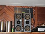 une étagère sur laquelle sont posés des haut-parleurs et une chaîne hi-fi