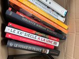 many books stacked on top of each other in a box
