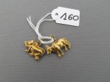 two small gold animals are on a string with a price tag