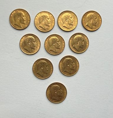 several gold coins are arranged in a triangle on a white surface