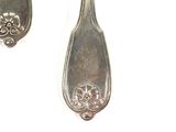 two spoons and a fork on a white surface
