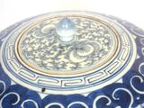 a large blue and white vase with a gold rim