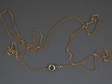 a close up of a gold chain with a clasp on a gray surface