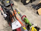several lawn mowers are lined up in a garage with tools on the floor