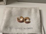 a pair of gold rings sitting on top of a white cloth