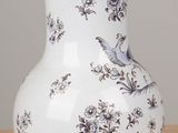 a white and blue vase sitting on a wooden table