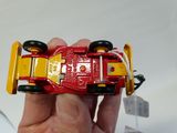 a person holding a red toy car in their hand