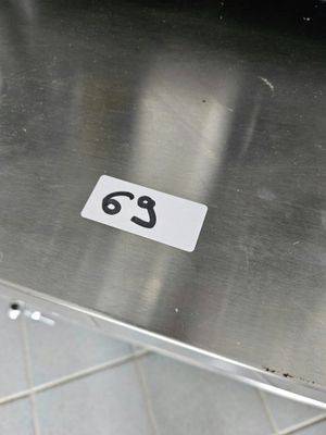 une table en métal portant un numéro, posée sur un sol carrelé